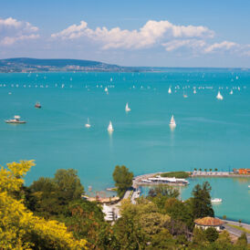 The picture shows Lake Balaton in Hungary, which is one of the project areas of "Nature without Barriers". The sun is shining, many ships sail on the lake.